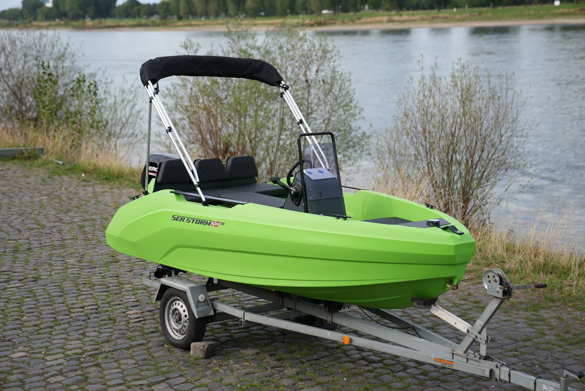SeaStorm 12 in Lime Green mit Bimini-Verdeck auf dem Trailer, Ansicht schräg von vorn